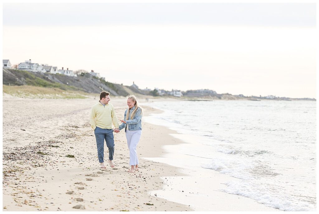 Newly engaged couple walk along Steps Beach in Nantucket.