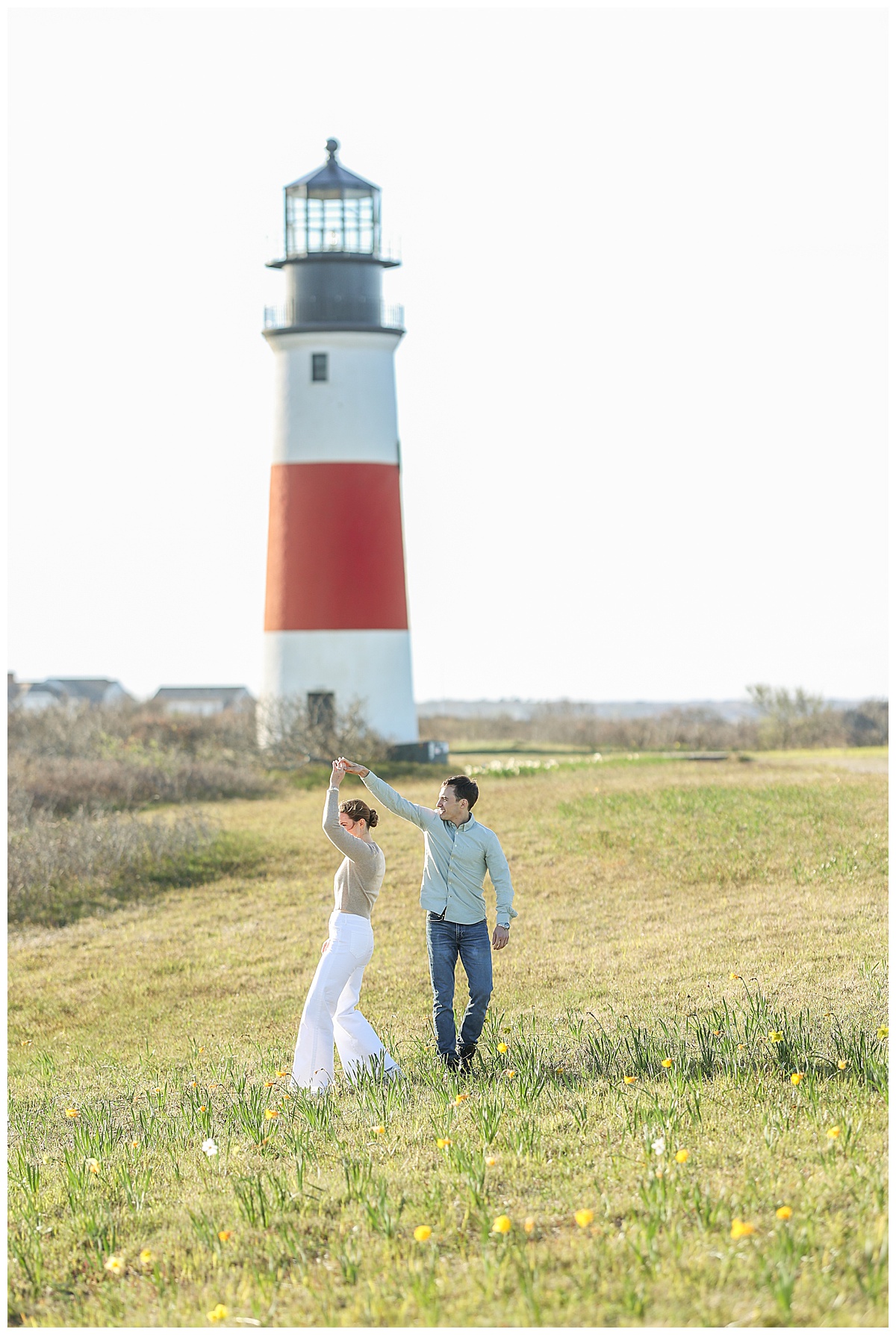 Nantucket engaged couple dances in front of the Sankaty Head Light in Sconset at sunset.
