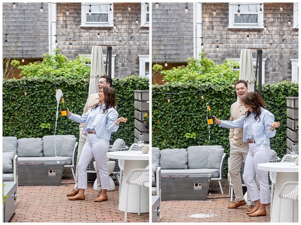 Couple pop a bottle of champagne at Hotel Pippa outside on the patio in Nantucket during engagement pictures.