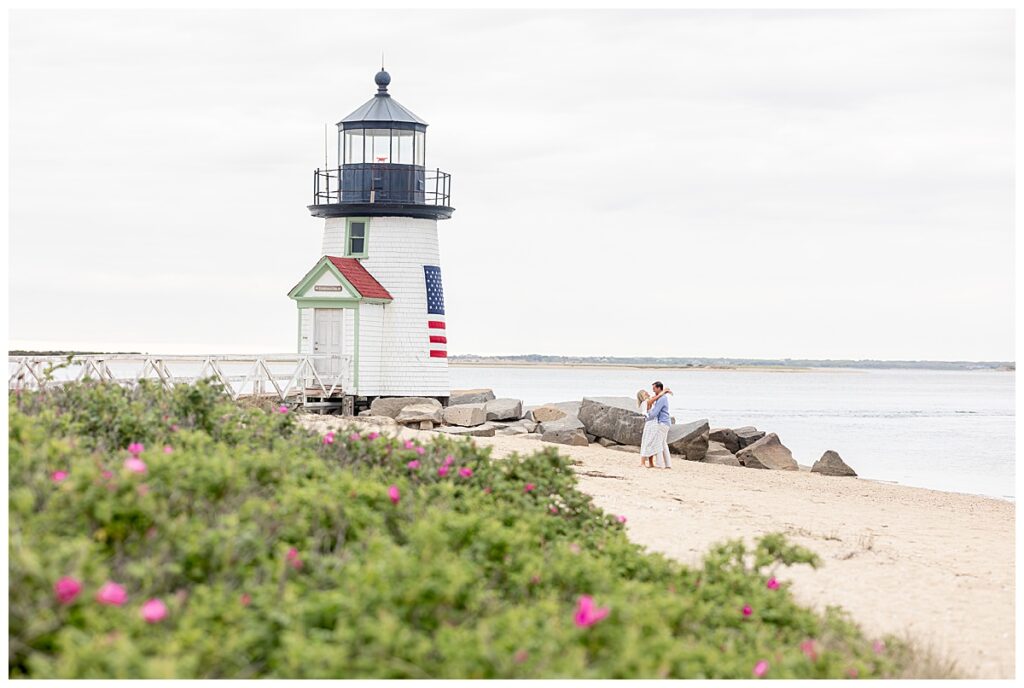 Couple embrace and stare lovingly at one another at Brant Point Lighthouse in Nantucket after the Nantucket Proposal.