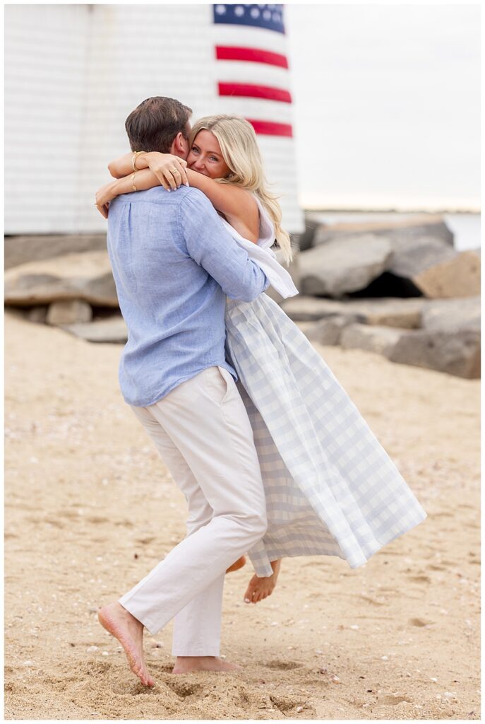 Man swings woman around in celebration and excitement in Nantucket after his Nantucket Proposal at Brant Point Lighthouse.