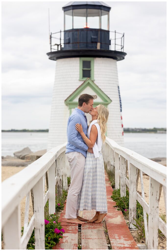 Couple kiss on the bridge of the Brant Point Lighthouse in Nantucket after the man did his Nantucket Proposal and she said Yes!