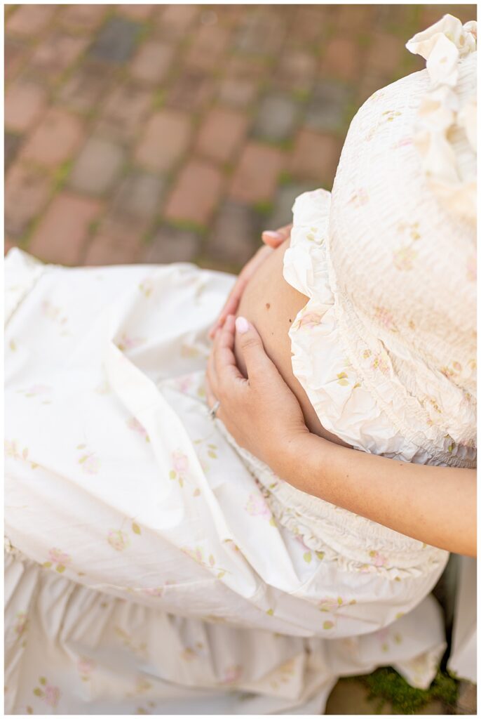 Woman holds her pregnant belly during Nantucket Maternity pictures.