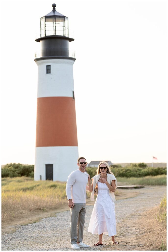 Man surprises girlfriend with a Nantucket Proposal in front of the Sankaty Head Lighthouse on a warm summer evening in July.