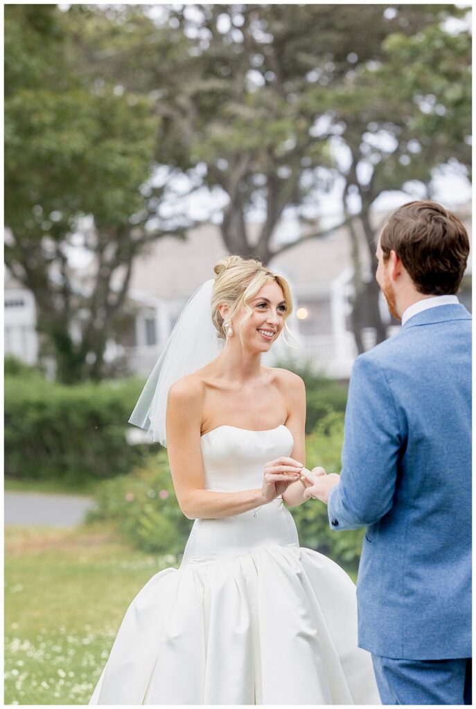 Bride places the ring on her grooms finger during vows at their Chatham, Cape Cod wedding.