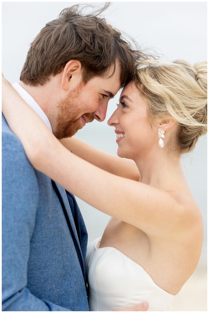 Bride and Groom touch foreheads and smile lovingly at one another on the beach at their Chatham, Cape Cod wedding.