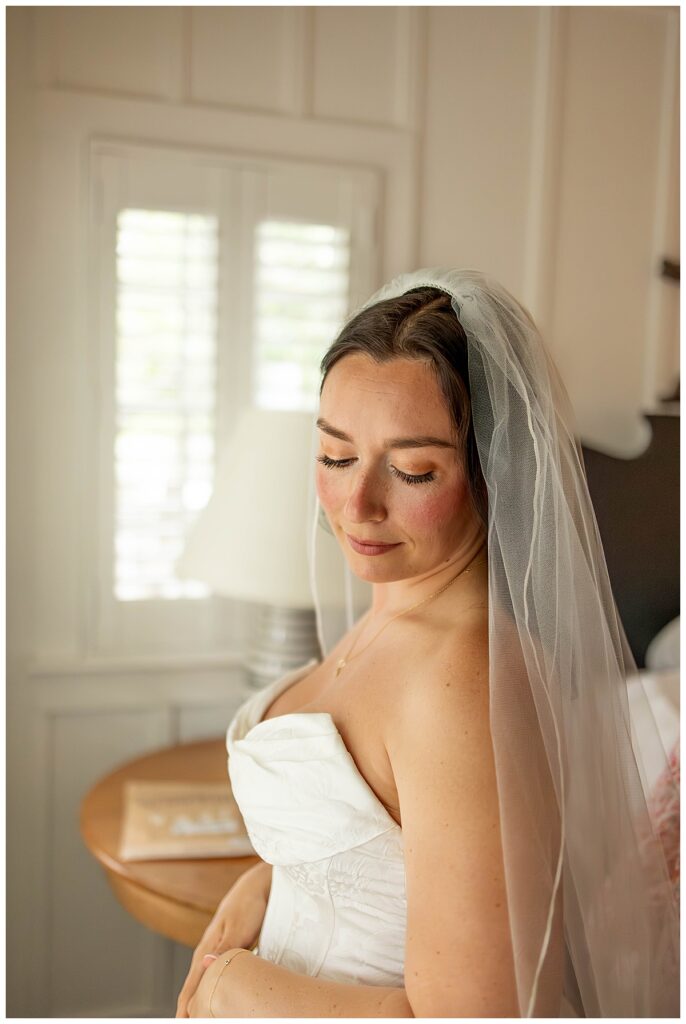 Bride looking lovingly down her shoulder at her suite at The Wauwinet in Nantucket on her wedding day.