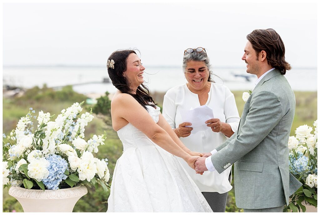 Bride and groom laughing while holding hands on the Zen Deck at The Wauwinet in Nantucket.