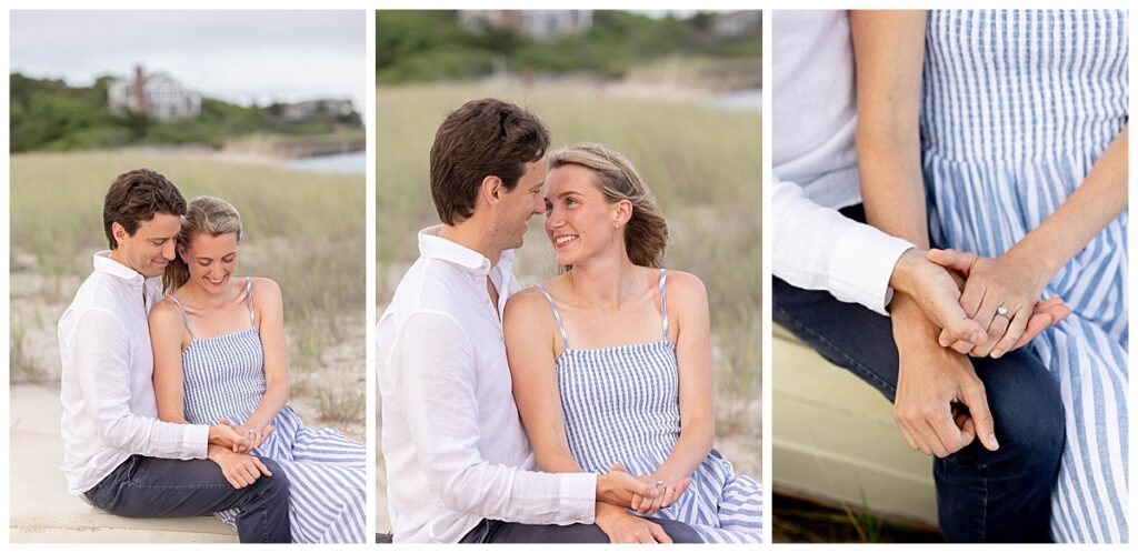 Man and woman sit in the seagrass holding hands while looking at the womans new ring after getting engaged in Chatham, Cape Cod, Massachusetts.