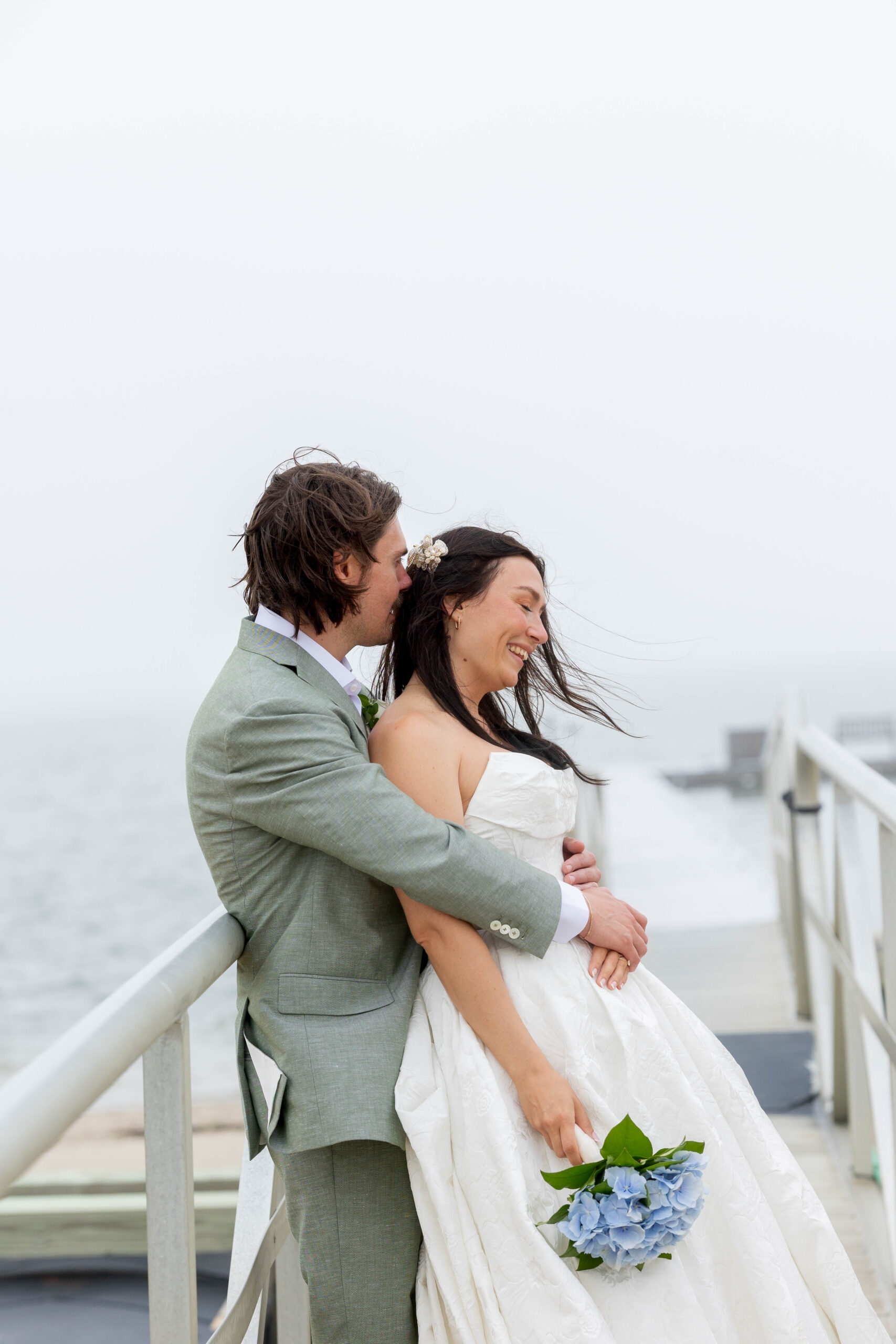 Bride and groom embracing and smiling on their wedding day at The Wauwinet in Nantucket.