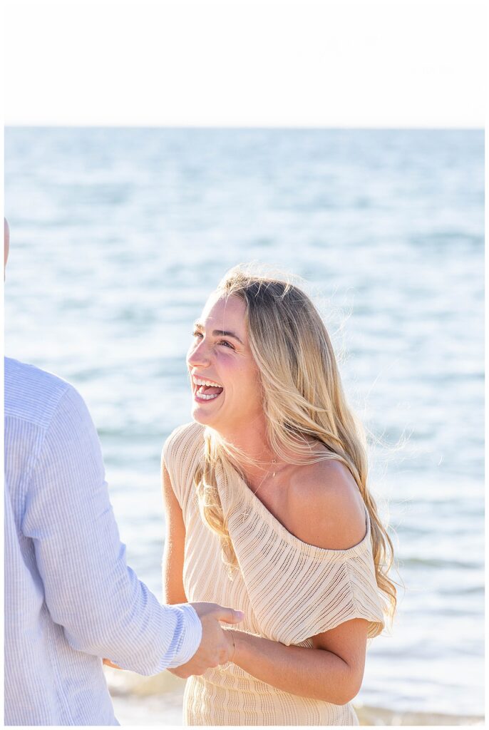 Woman smiles and laughs after being surprised that her boyfriend pulled off a Nantucket Proposal at Steps Beach over Labor Day weekend.