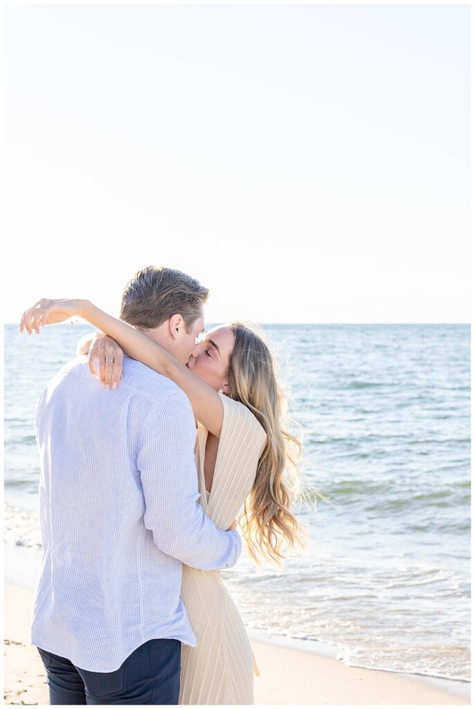 Man and woman share a kiss on Steps Beach after mans Nantucket Proposal.