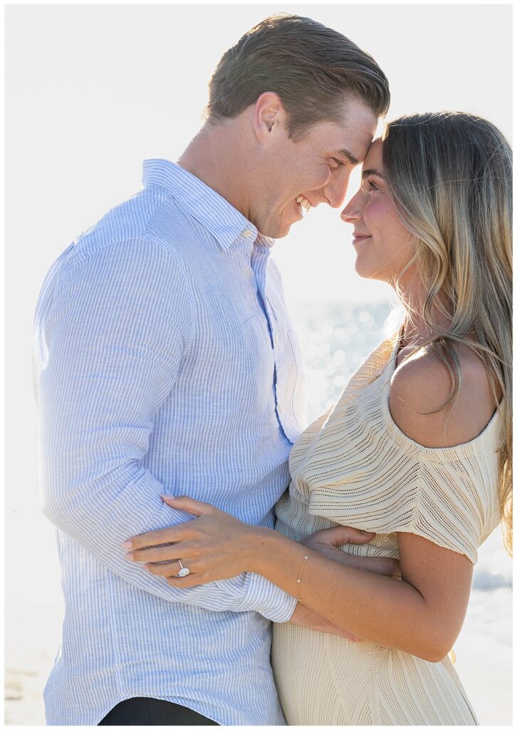 Man and woman lock eyes and touch foreheads and smile at Steps Beach after his Nantucket Proposal over Labor Day weekend.