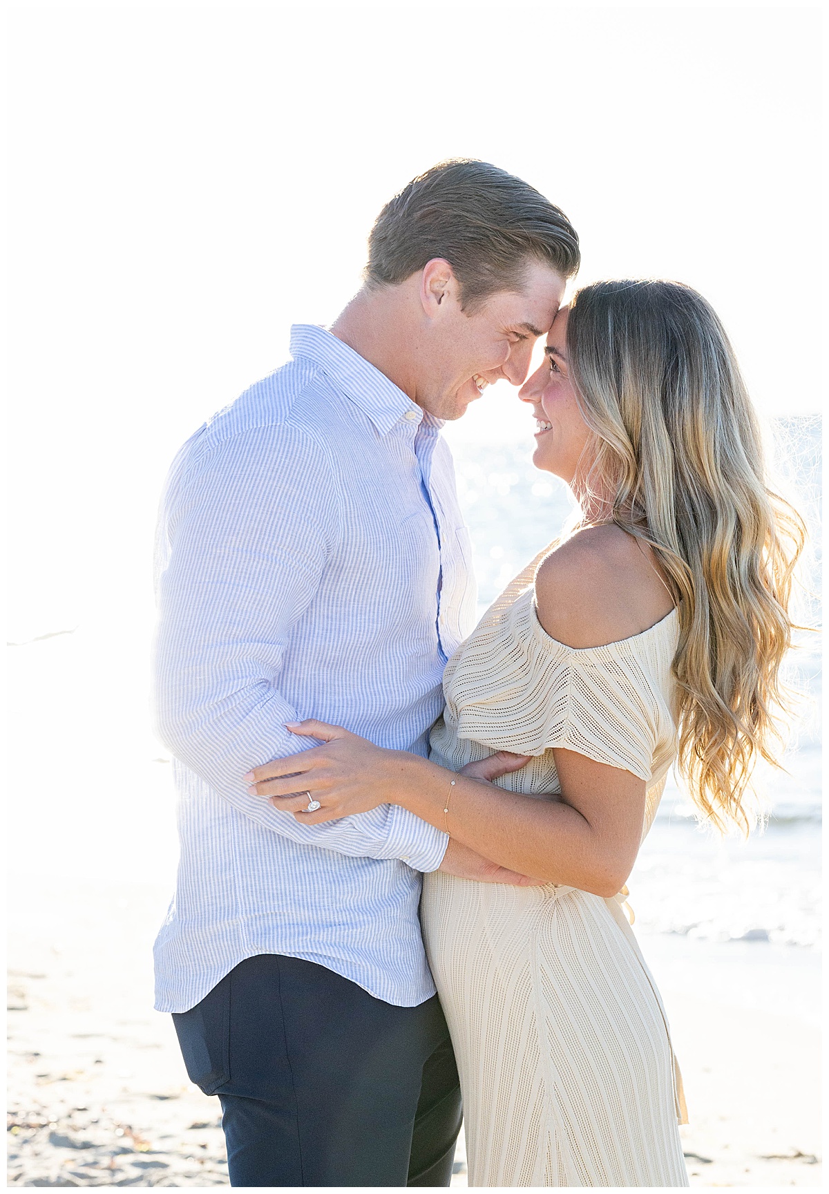 Man and woman touch foreheads and smile at one another after his Nantucket Proposal on Steps Beach over Labor Day weekend.