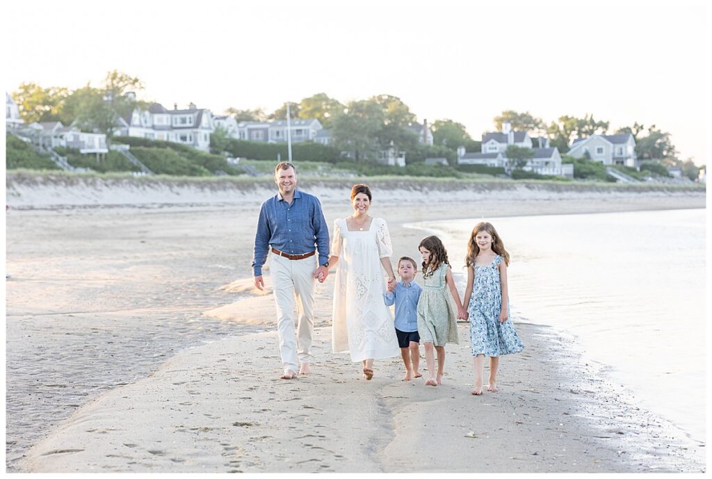 Family walks along the beach at sunset at Chatham Lighthouse Beach in Chatham, Cape Cod, Massachusetts.